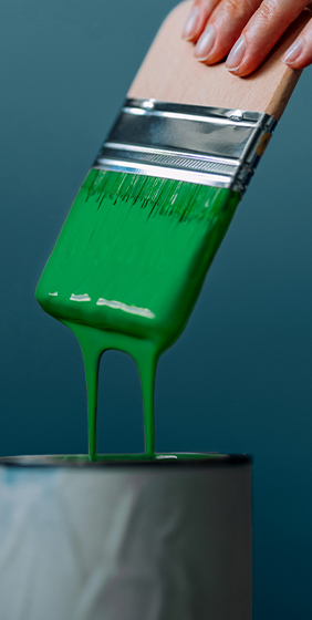 Pinceau couvert de peinture verte dégoulinante.