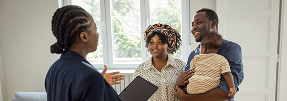 Un professionnel parle avec deux parents qui tiennent leur bébé.