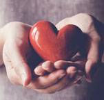 Picture of a female holding a red heart in her hands.