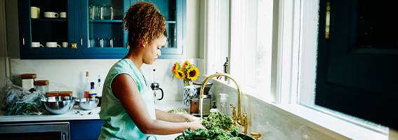 Femme dans la cuisine préparant un repas