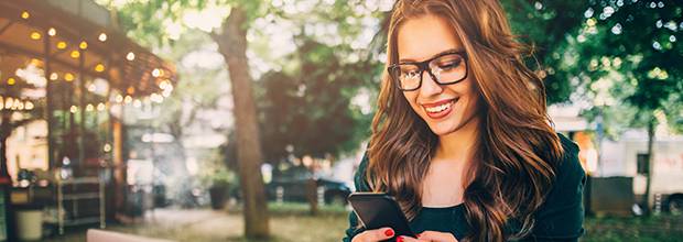 Femme qui télécharge une application sur son téléphone cellulaire.